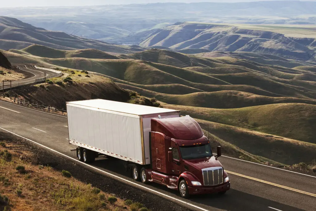 A-commercial-semi-driving-through-a-hilly-landscape