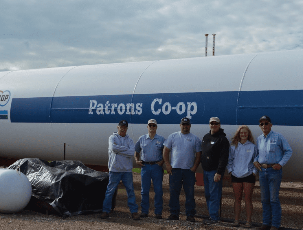 Patrons Cooperative Association staff in front of propane tank