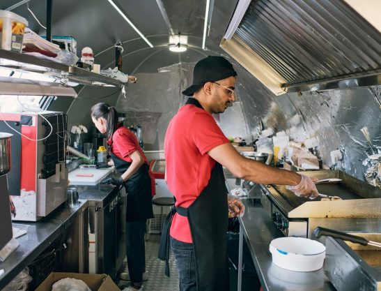 Crew-working-in-a-food-truck-kitchen-during-a-rush-serving-hundry-customers